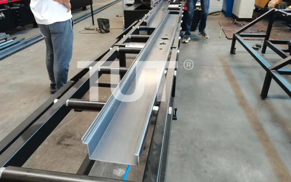 Long steel beam section leaving the run-out table of a heavy gauge forming line