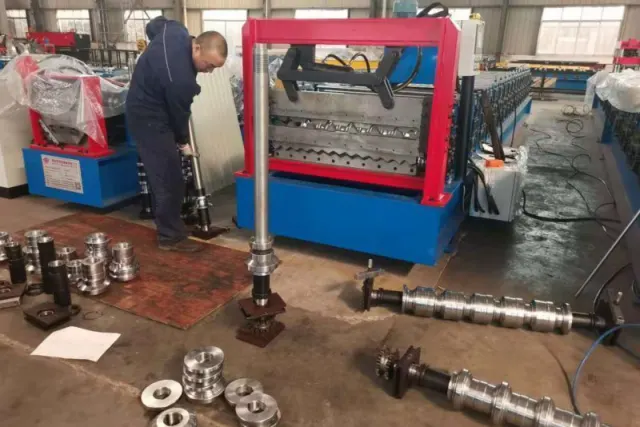 Technician fitting forming shafts and rollers during machine assembly